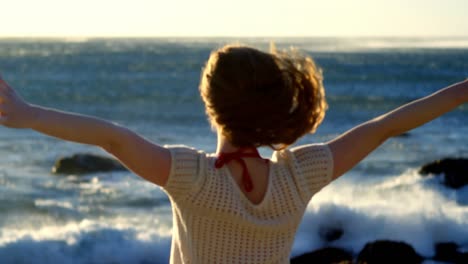 Woman-standing-with-arms-outstretched-in-the-beach-4k