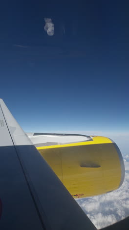 view from a plane window of the sky with the wing of the plane in shot in vertical