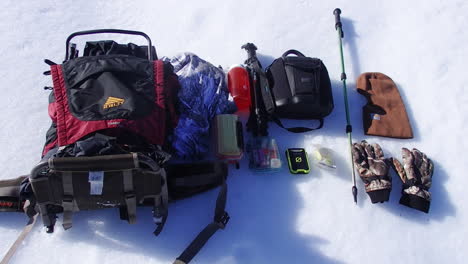 nature and wildlife photography and outdoor gear from a backpack on display in the snow during a winter on kodiak island alaska