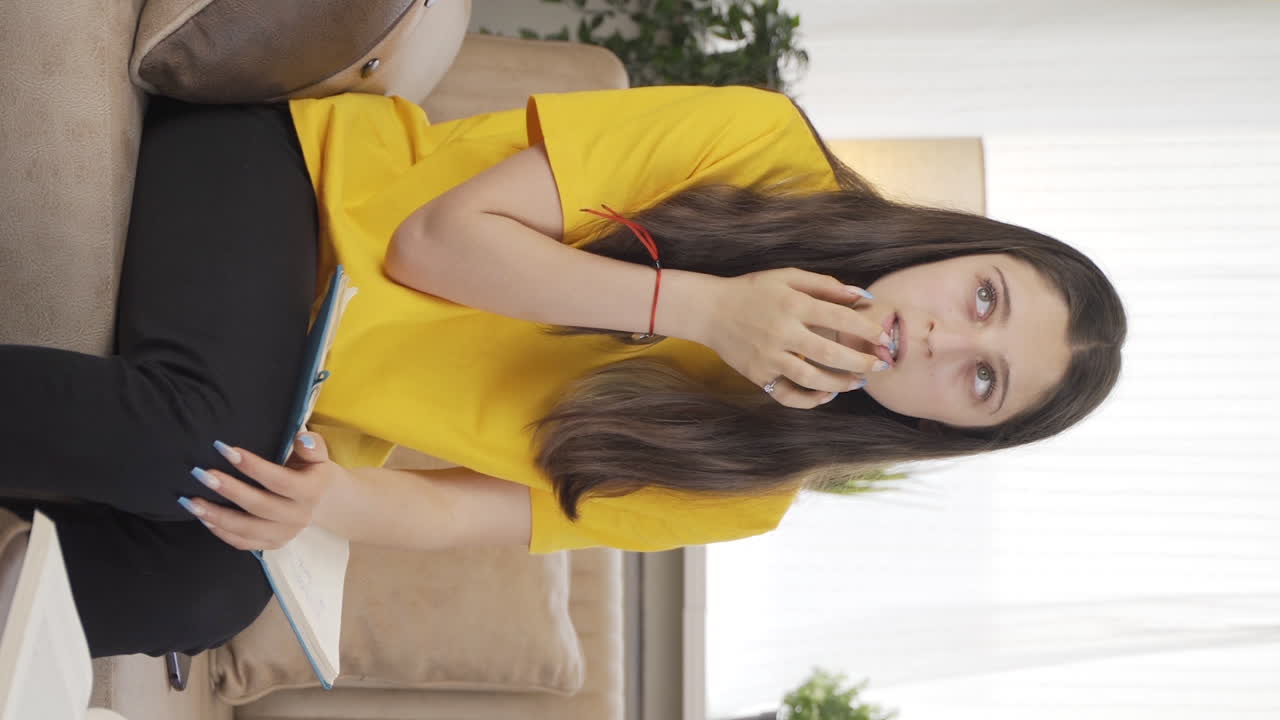 여성 학생이 스트레스를 받고 손 ⁇ 을  ⁇ 는 수직 비디오.