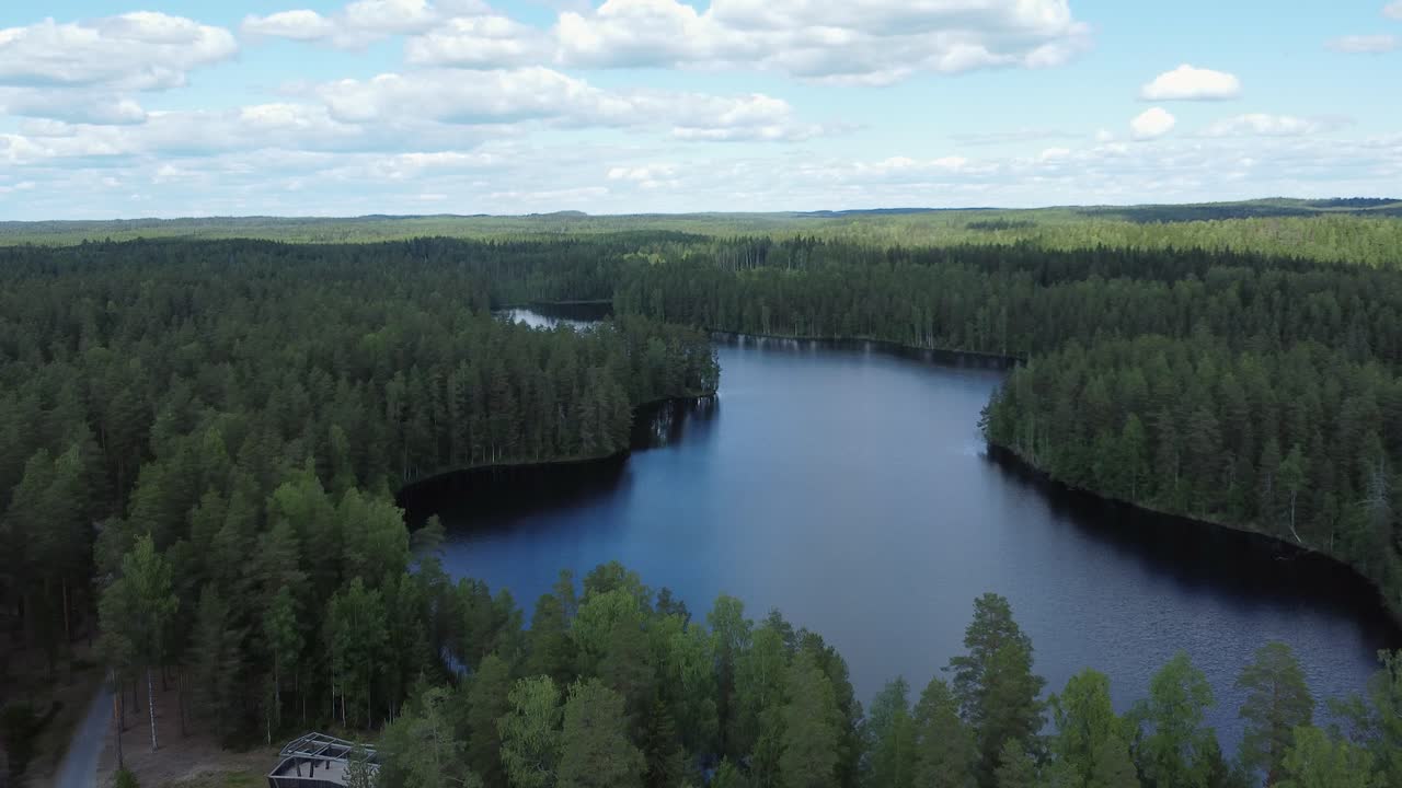 Flyover dolly of natural silky blue lake in northern boreal forest