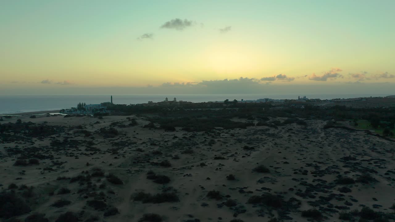 Scenic drone trucking pan over Maspalomas dunes at dawn, with soft sunlight illuminating the sandy terrain