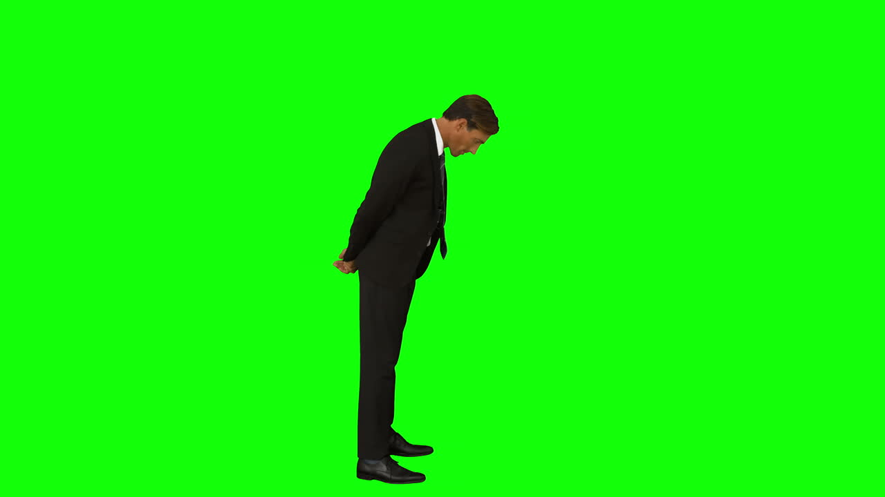 사업가 가 뒤 에 손 을 고 아래 를 바라보며 서 있다