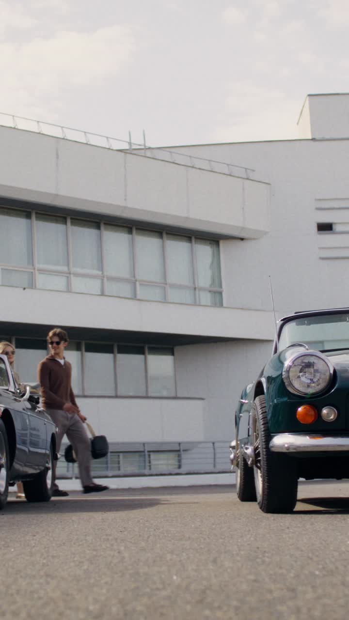 Classic Cars and People in Front of a Modern Building