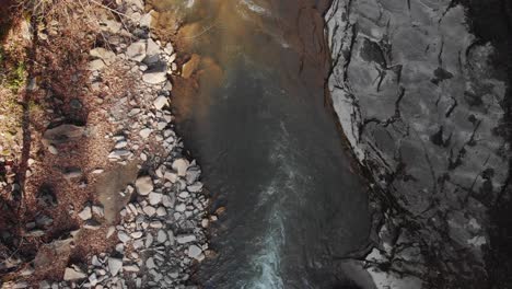 Aerial-view-of-a-mountain-river-with-beautiful-waterfall-in-the-afternoon-sunlight