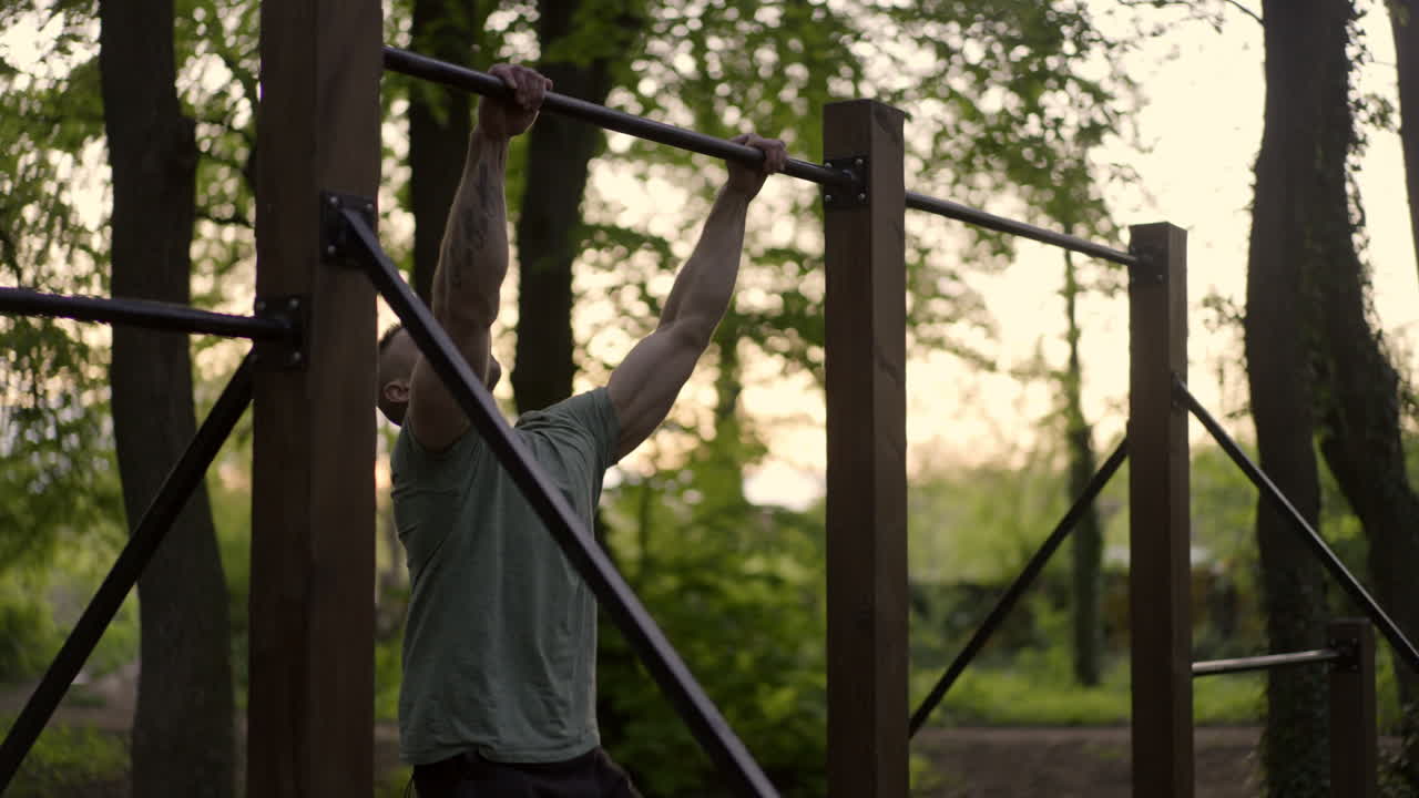 Man doing pull-ups outdoors in a park