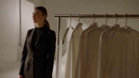 woman in blazer with clothing rack