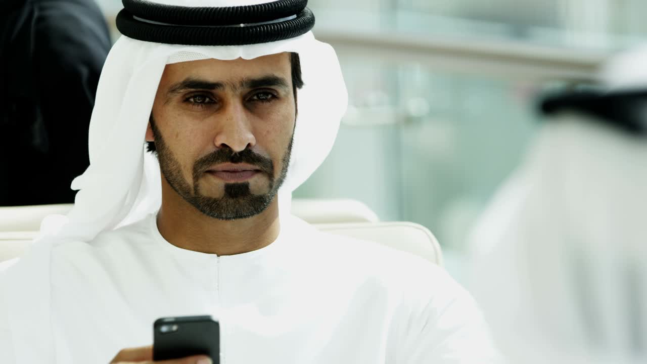 gli uomini d'affari di dubai si incontrano usando la tecnologia degli smartphone