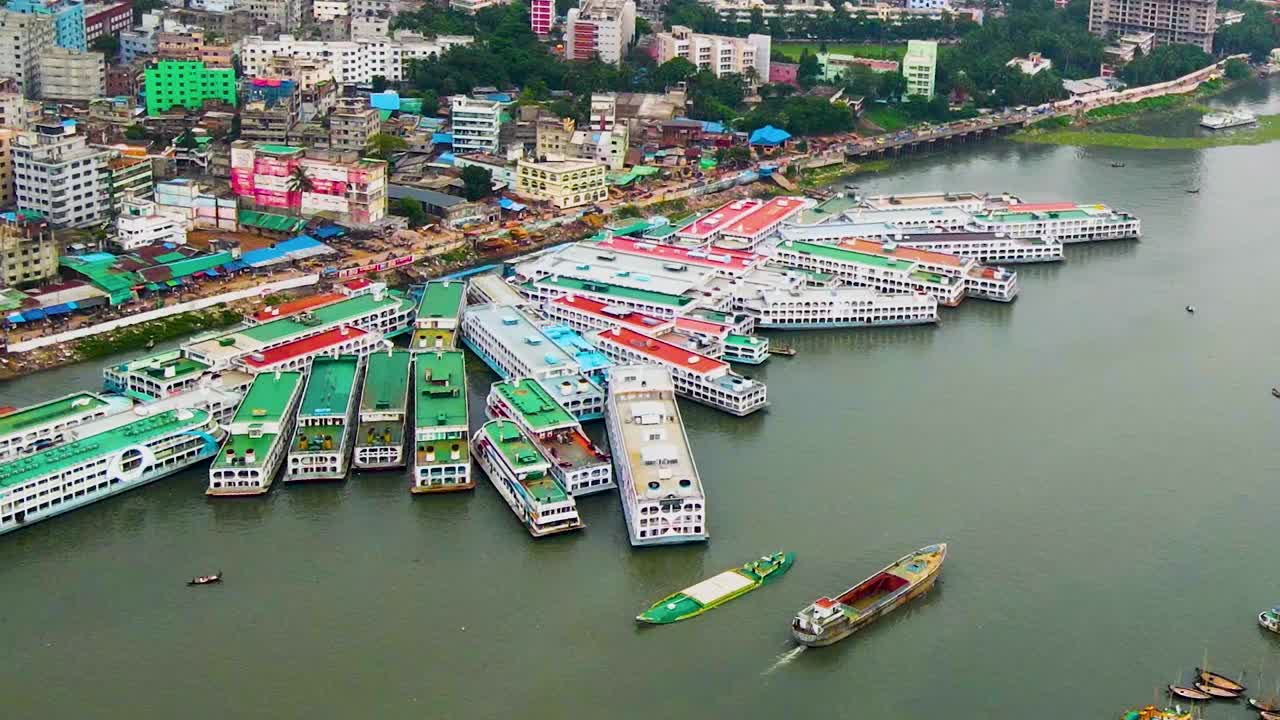 Vista aerea di un molo affollato lungo il fiume Buriganga con molte barche a vela attraccate al cantiere navale nella città di Keraniganj, Dacca, Bangladesh