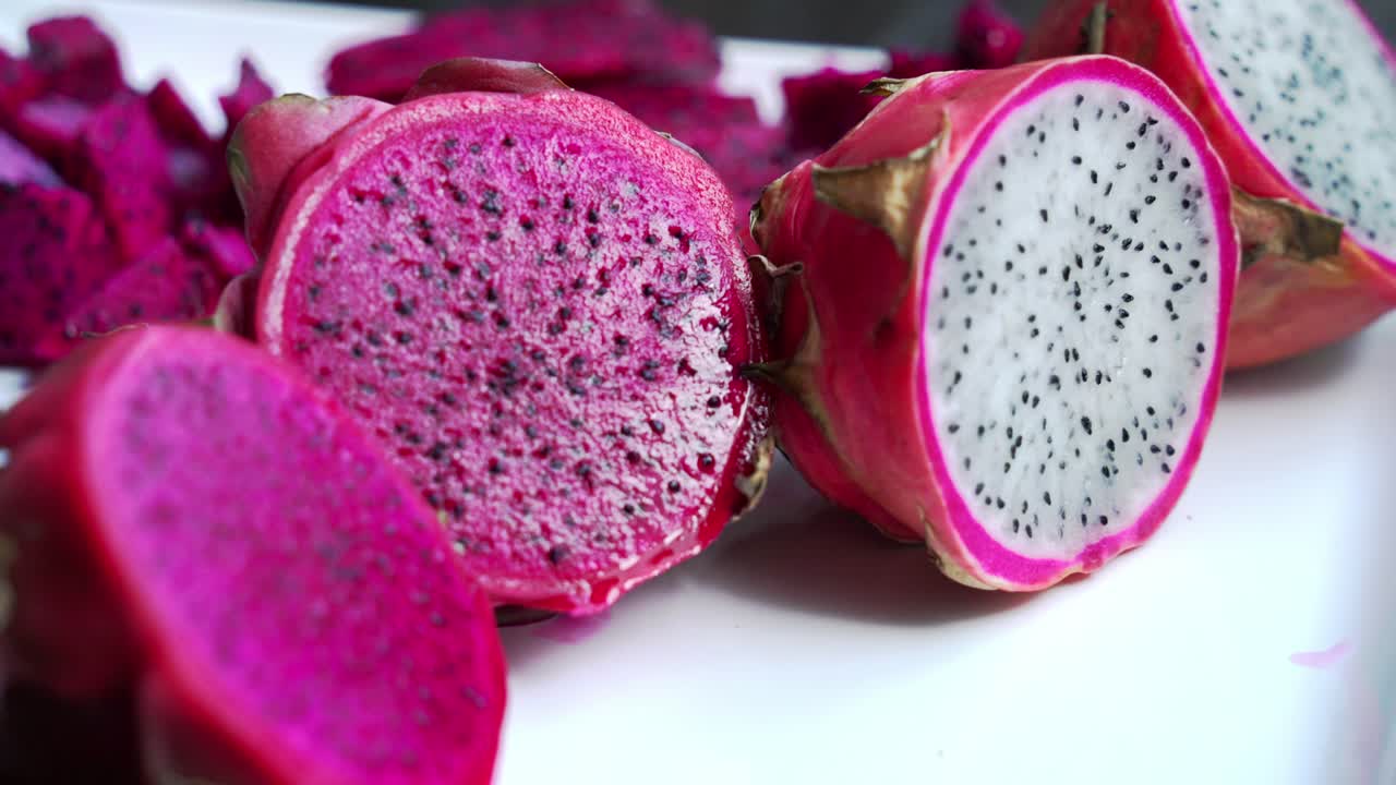 panorámica de primer plano de frutas de dragón rojas y blancas rebanadas de frutas del dragón rojo y cultivo de plantas exóticas pitaya