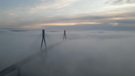 Replot-bridge-pillars-above-foggy-landscape,-Orbiting-drone-shot,-Finland