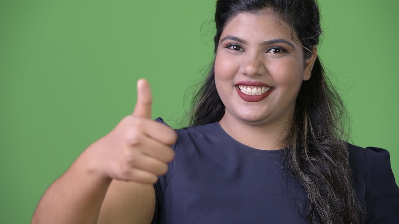 joven sobrepeso hermosa mujer de negocios india contra fondo verde