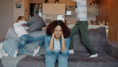 kids pillow fight and tired mom