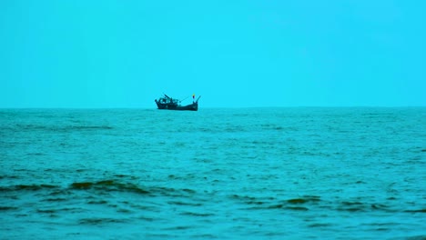 A-Fishing-Trawler-Boat-rocking-around-on-the-Coast-of-Kuakata,-Bangladesh,-in-the-Indian-Ocean-on-a-cold-gloomy-day