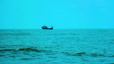un barco de arrastre de pesca balanceándose en la costa de kuakata, bangladesh, en el océano índico en un día frío y sombrío