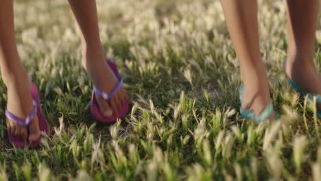 close up of childrens feet jumping on soft green grass enjoying summertime