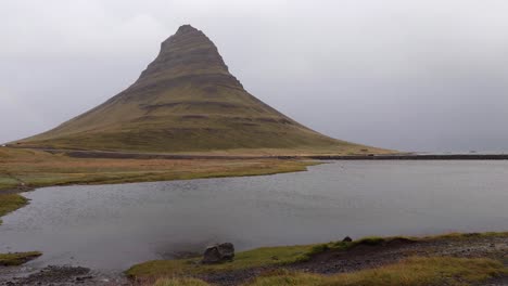 la famosa montaña de kirkjufell en un día lluvioso en la cascada de kirkjufellsfoss