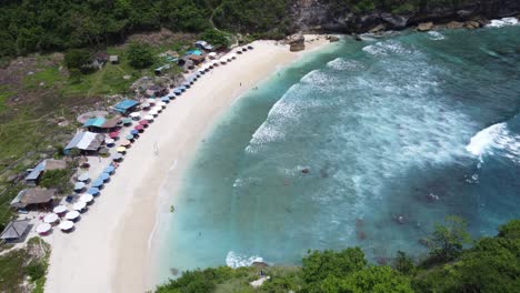 aerial establishing view of tropical sunlit atuh beach in nusa penida island, bali indonesia