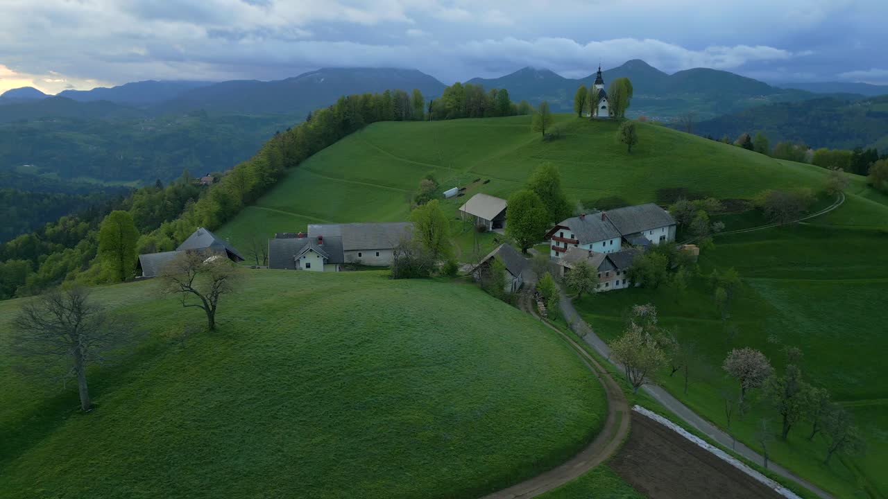 Surujen Neitsyt Marian kirkko Bukov Vrissä, Gorenja Vas–Poljanessa, Sloveniassa – Kiertävä dronekuva.