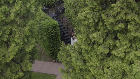 Newlyweds,-caucasian-groom-with-bride-stay-on-stairs-in-park,-wedding-couple,-man-and-woman-in-love