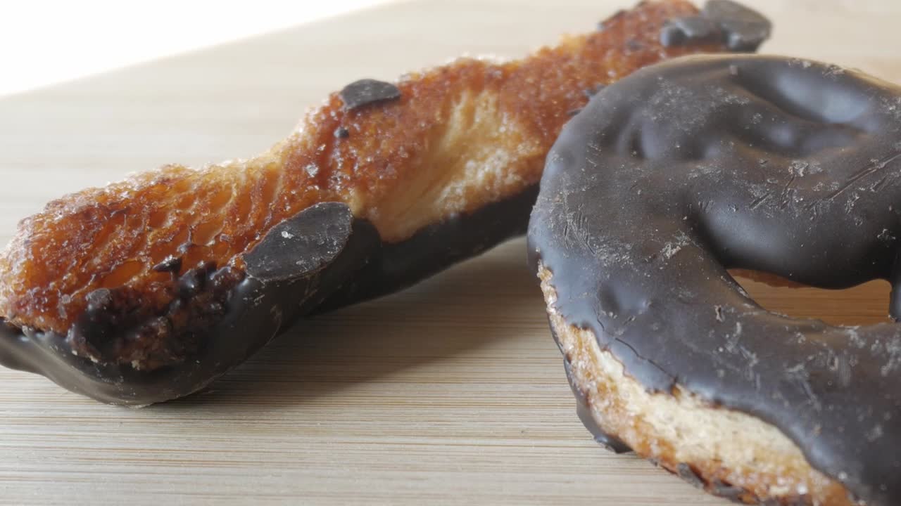 Chocolate-coated palmeras pastry on a wooden surface, showing texture and details