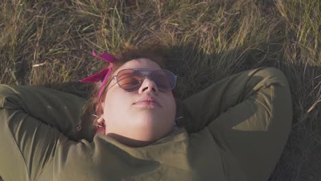 Una-Joven-Regordeta-Con-Gafas-De-Sol-Duerme-Sobre-Hierba-Seca