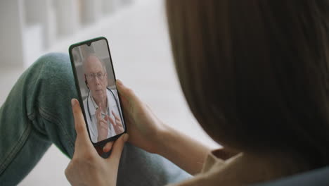 asistente médica usa casco blanco auriculares video llamando a un paciente distante en el teléfono inteligente. médico hablando con el cliente usando una aplicación telefónica de chat virtual. telemedicina servicios de atención médica remota