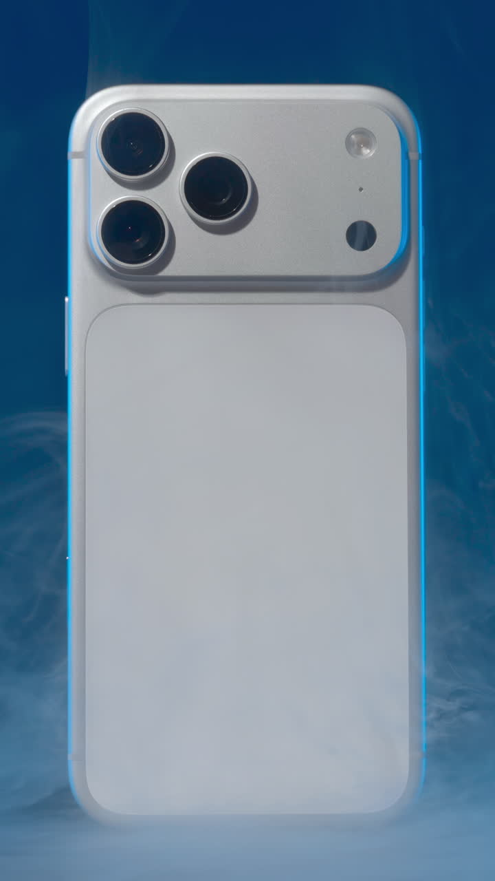 Next generation smartphone with a new camera system rotating slowly on a blue background with fog. Action
