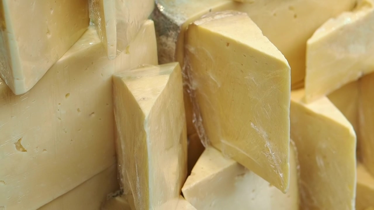 Spicchi di formaggio giallo avvolti in pellicola di plastica