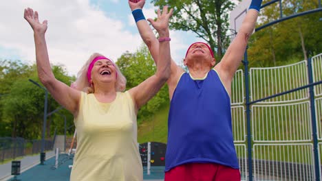 active senior sports team athletes putting arms hands together, cheering and ready to win, smiling