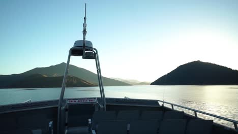 early morning sunrise boat cruise in queen charlotte sound, new zealand with mountains in background