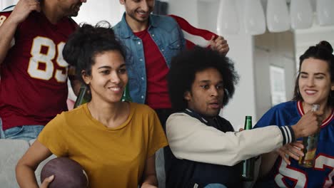 Handheld-video-of-excited-group-of-friends-watching-TV