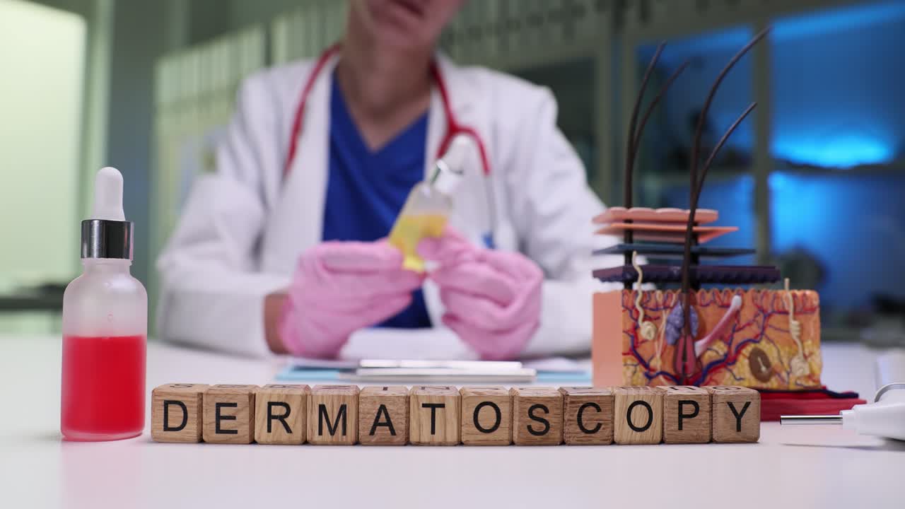 Cubetti di legno compongono la parola dermatoscopia su una scrivania clinica dal medico.