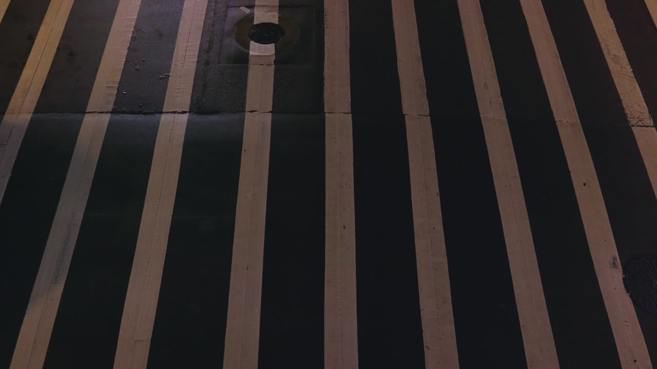 밤에 자동차가 지나가는 횡단보도의 탑다운 샷 – 미디엄 샷