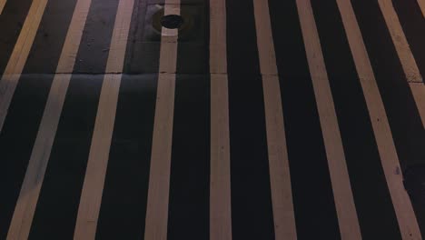 toma de arriba hacia abajo de un paso de peatones con autos que pasan por la noche - plano medio