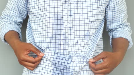 hands adjusting a blue checkered shirt