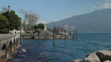 Waves-of-lake-garda-crash-into-the-shore-on-a-sunny-day