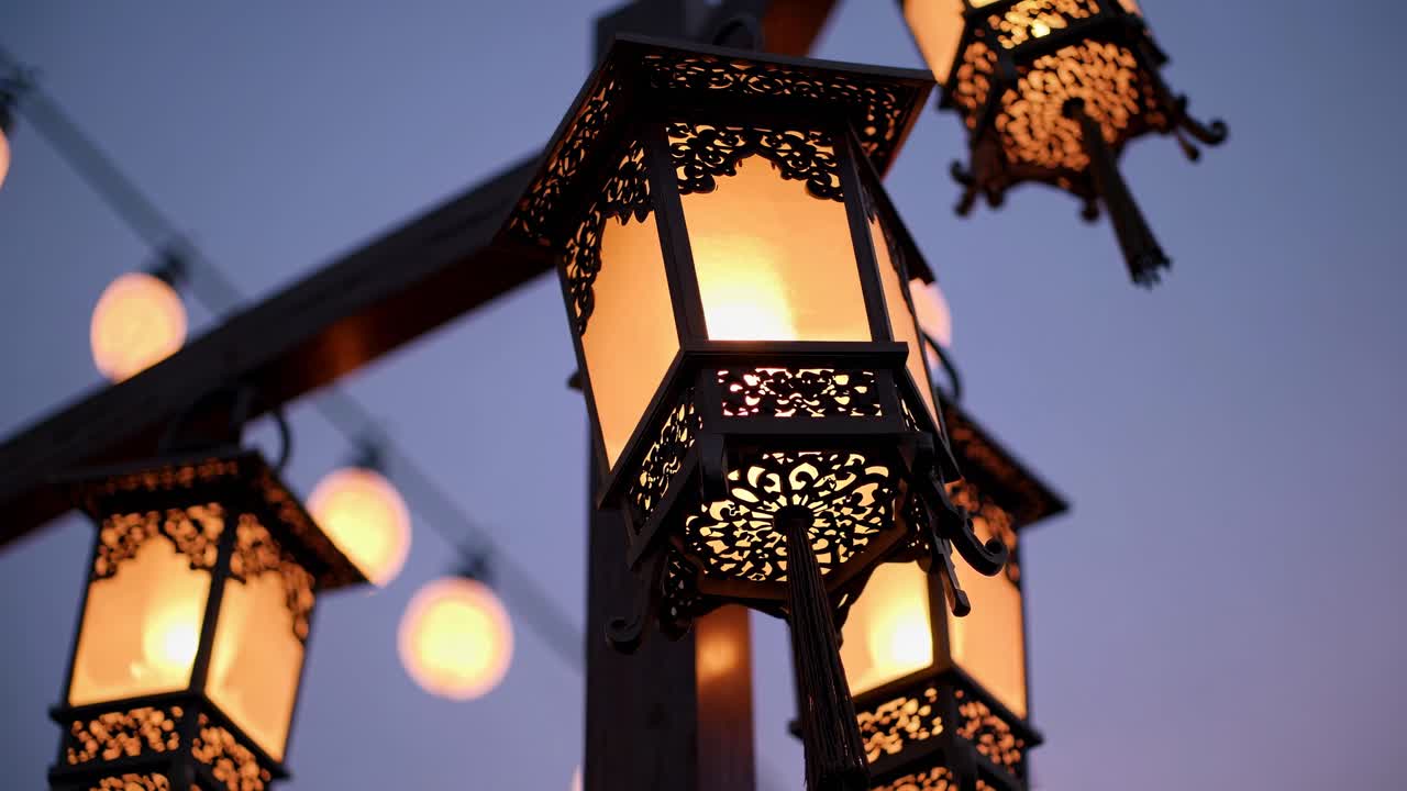 Warmly lit lanterns with intricate designs, captured from a low angle