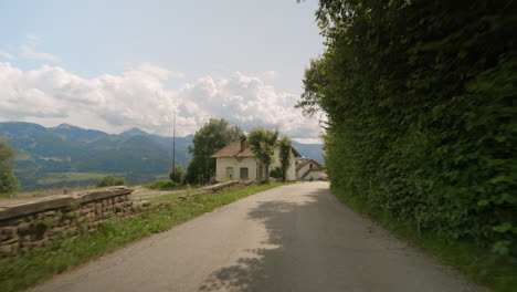 POV-car-driving-on-a-mountain-road,-mountains-background,-small-town-road