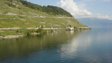 overflying two paddlers on lake léman in front of lavaux - switzerland summer colors and mirror like water