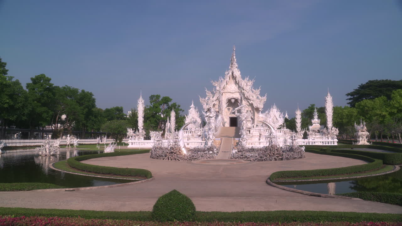 Glowing white Wat Rong Khun white temple at midday, famous landmark in Chiang Rai, Thailand