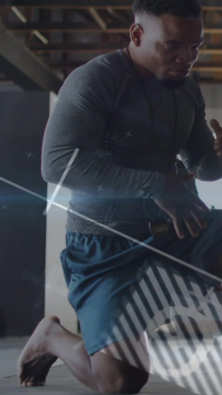 Vertical video: Man kneeling grasping waist strap and tuning device for fitness as HUD over torso