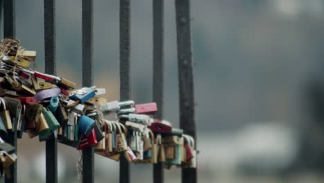 Colorful-padlocks-hang-on-old-iron-gate,-shallow-depth-of-field