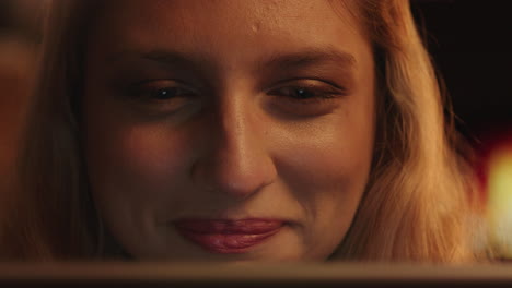 retrato de cerca de una mujer hermosa usando una tableta viendo una película riendo disfrutando de entretenimiento cómico relajándose en casa