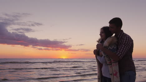 the care and warmth man brings warm clothes beloved which was frozen on the beach at sunset