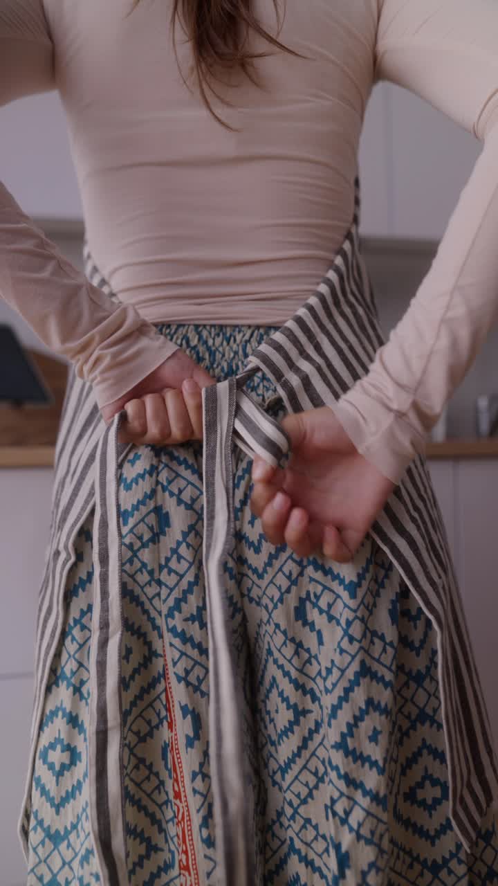 Woman tying an apron in a kitchen