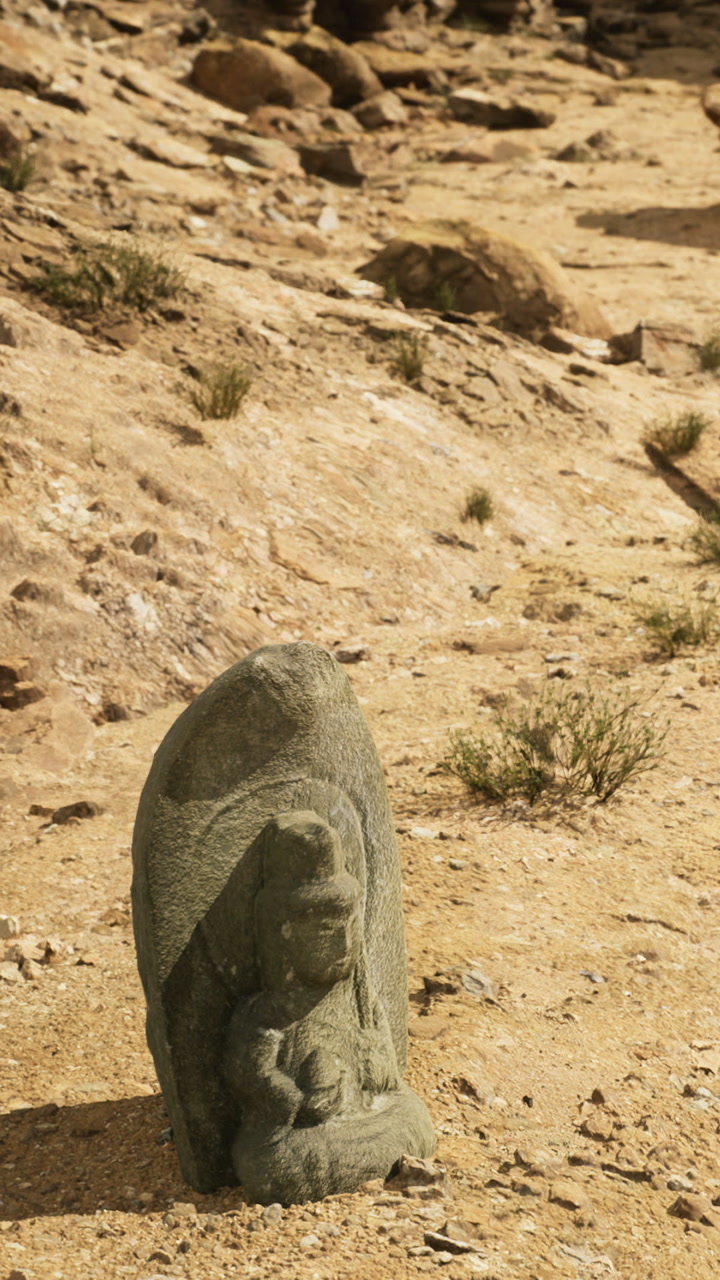 Ancient stone sculpture stands majestically in a rugged dry landscape