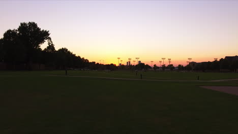 low aerial shot through a park with a vibrant sunset on the horizon in georgia