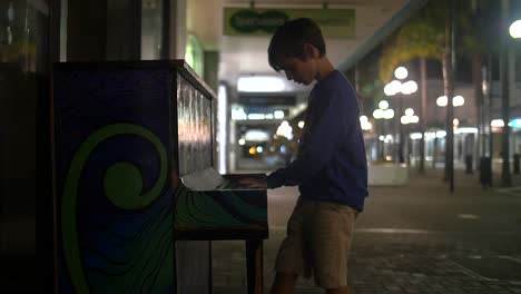 young boy playing piano in the street 2