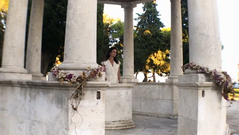 pretty young woman in white dress walking the landmark of sustipan park in perfect sunset, split, dalmatia, croatia